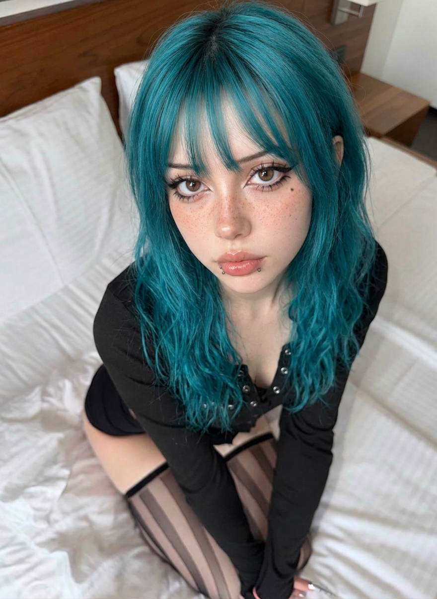 Leila with teal hair looking up at the camera