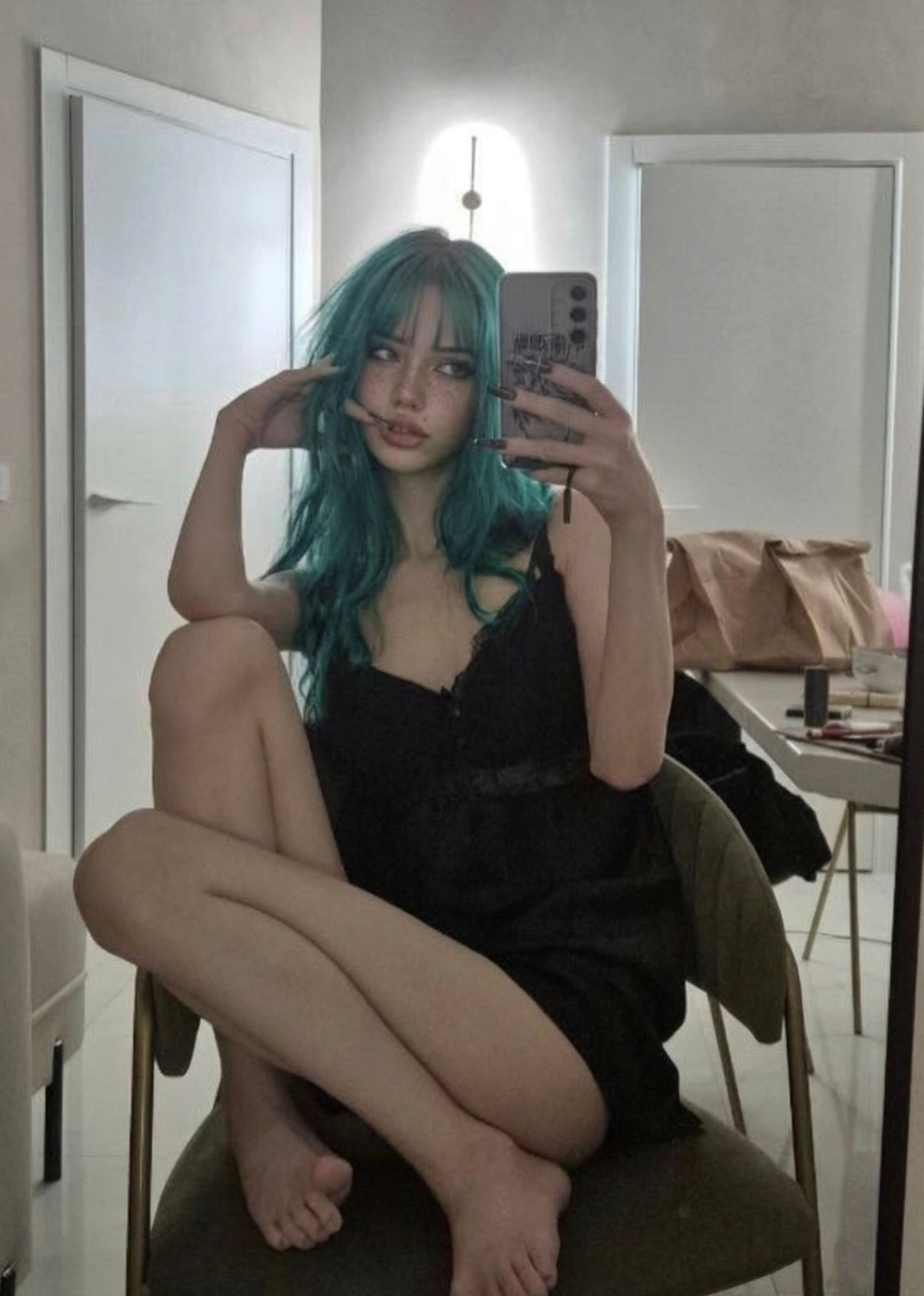 Leila taking a mirror selfie in a black dress